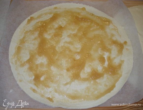 Тесто раскатать на пергаменте (это важно, т. к. потом на пергаменте его будем перекладывать на противень)  и вырезать два круга по размерам формы, в которой пирог будет печься. Один круг смазываем джемом  (у меня яблочный).