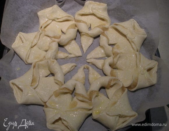 Завернуть вверх два других уголка на каждом куске. Сверху смазать слегка взбитым яйцом (не обязательно, можно сбрызнуть водой) и посыпать сахаром.