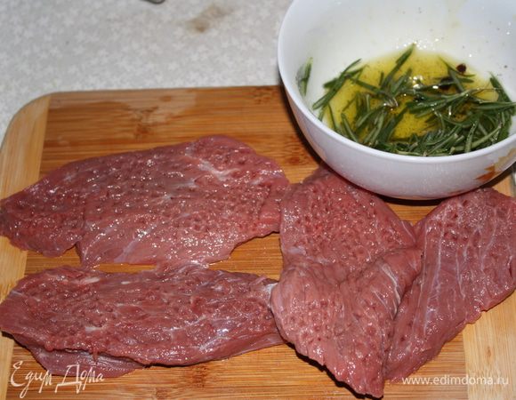 Тщательно отобьем мясо и приготовим маринад для него. Оливковое масло смешать с олью, перцем, розмарином и толчеными ягодами можжевельника.  Натереть мясо маринадом и оставить нариноваться на полчаса.