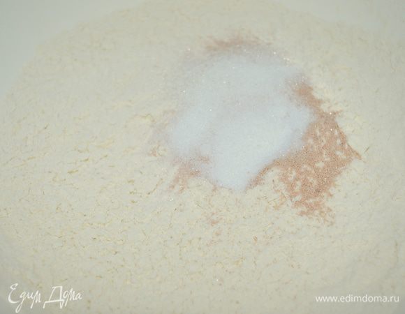 В большой миске смешать муку (просеять), дрожжи, соль и сахар. 