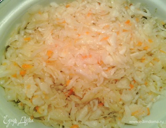 Положите на мясо слой квашеной капусты (если вы очень любите квашеную капусту, смело увеличивайте ее количество).