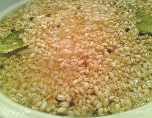 Залейте водой так, чтобы она чуть-чуть прикрывала перловку. Если у вас есть сок от квашенной капусты, добавьте его вместо воды. Не перемешивайте!<br />
Посолите, поперчите, добавьте сахар, лавровый лист и горошек. Накройте крышкой и поставьте в разогретую до 175°C духовку на 1,5 часа (можно чуть меньше, я последний раз готовила 1 час 20 минут).