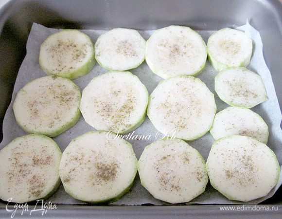 Кабачок нарезать кружочками и выложить на пергамент в форму для запекания. Пергамент смазать маслом. Каждый кружочек кабачка тоже смазать маслом, посыпать перцем, специями и подсолить. Запечь в духовке до готовности.