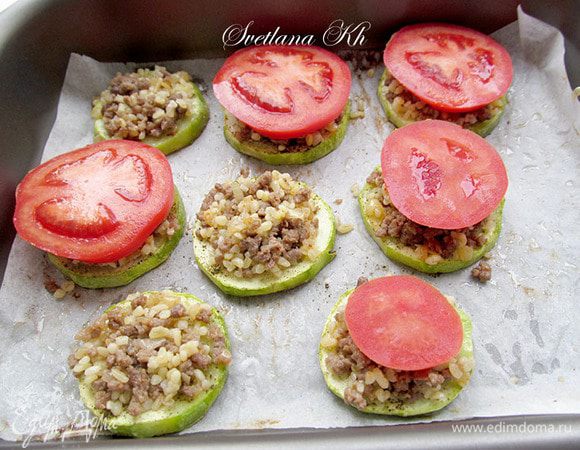 На каждый кружочек кабачка выложить фарш, затем колечко помидора,