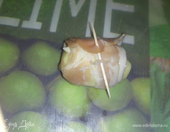 Картофель почистить и сделать на каждом поперечные разрезы. На картофель положить прозрачный ломтик сливочного масла, завернуть в полоску бекона и закрепить зубочисткой.