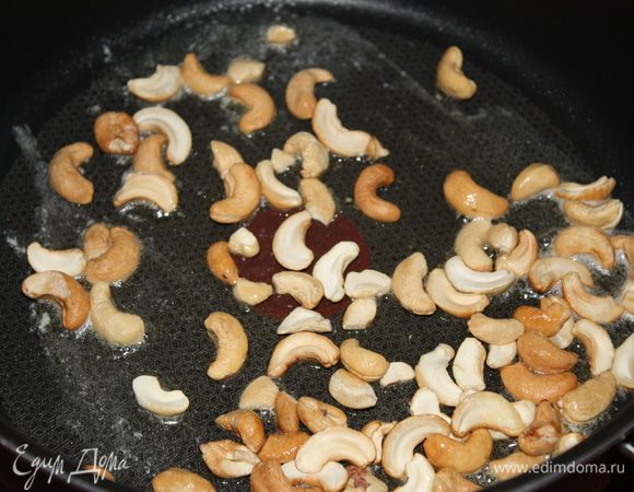 В глубокой тяжелой сковороде разогреть слив.масло и обжарить кешью.