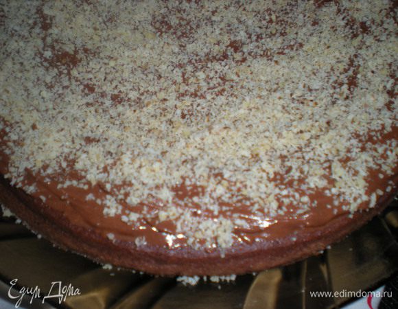 Сверху посыпать измельченными орехами и накрыть вторым коржом.