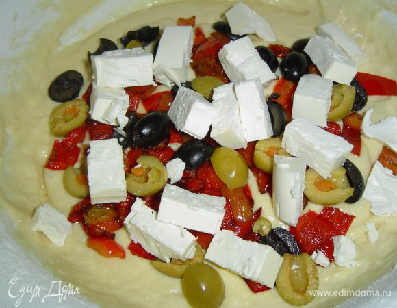 В тесто добавляем остывший перец, нарезанную кубиками фету, разрезанные пополам маслины и оливки.