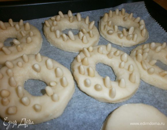 Перенести бублики на лист. Утыкать кедровыми орешками. 