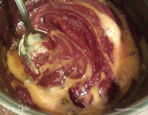 Немного охлаждаем шоколадную массу, но не давая ей остыть, вводим в нее желтки и тщательно перемешиваем.