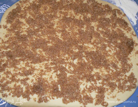 Поднявшееся тесто необходимо раскатать в большой прямоугольник, толщиной примерно 7 мм. Разложите равномерно начинку