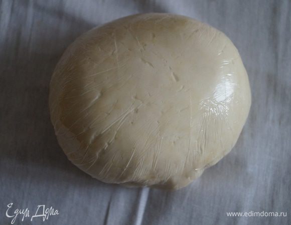 Постепенно добавляем растительное масло и вымешиваем эластичное нежное тесто. Не всыпать муку всю сразу, лучше немного оставить, так как разная мука может вобрать в себя разное количество воды, потом лучше добавить муку. Затем отбить тесто об стол, для этого взять тесто в руки и несколько раз шлепнуть его об стол. Завернуть в пищевую пленку и убрать в холодильник на 1 час.