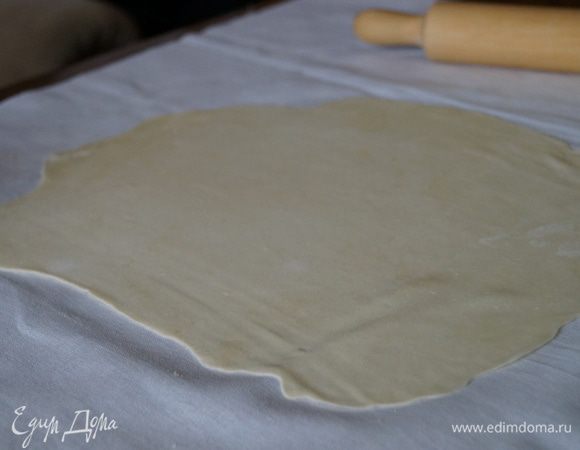 Накрыть стол тканевой салфеткой, посыпать мукой и взять кусочек теста и начать тонко раскатывать