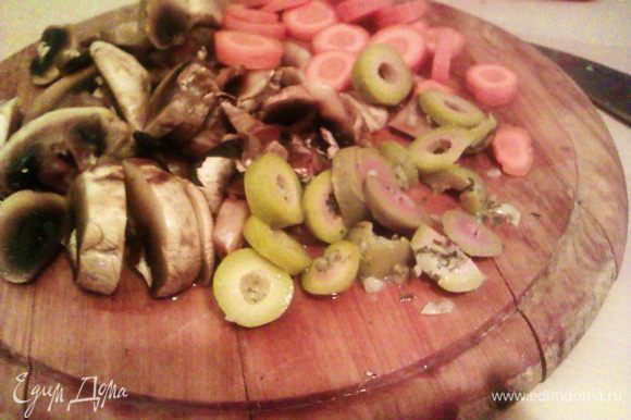 Нарезаем грибы, морковь и оливки тонкими кольцами. Снижаем огонь до среднего и обжариваем пару минут с мясом.