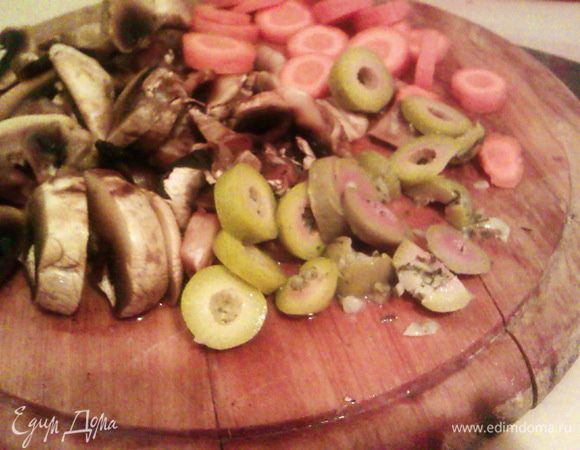 Нарезаем грибы, морковь и оливки тонкими кольцами. Снижаем огонь до среднего и обжариваем пару минут с мясом.