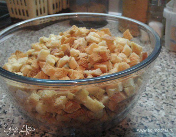 Хлеб порезать на кубики, можно брусочками, кому как нравится.  
Я делала мелкие кубики. 
Подсушить в теплой духовке, за несколько минут до готовности включить огонь посильнее, чтобы наши сухарики немного поджарились. Достать из духовки.