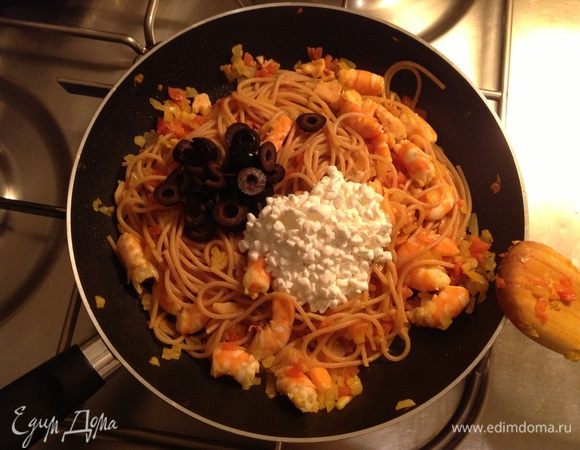 Добавить к макаронам оливки и творог. Тщательно перемешать и тушить под крышкой на слабо-среднем огне минут 5-7.
