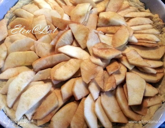 Корж достать их духовки и на него уложить яблоки, предварительно их  очистить и порезать на дольки.
