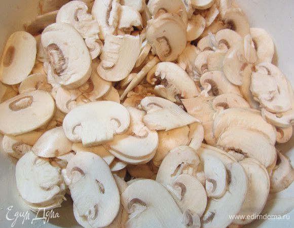 Порезать грибы на тонкие пласты и поставить тушить вместе с луком, добавив сливки, пока жидкость не испарится.