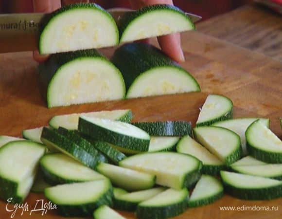 Цукини, не очищая, разрезать вдоль пополам, затем полукружьями.