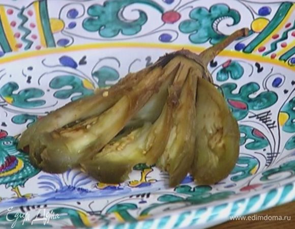 Придерживая за хвостик, нарезать мякоть баклажана полосками вдоль, так чтобы получился раскрытый веер, посолить, поперчить.