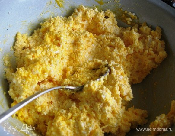 Теперь добавляем размягченное сливочное масло (но не совсем растаявшее), сахар и тщательно перемешиваем.  Желтки вводим в творожную массу. Добавляем изюм по желанию. Кладем цедру. 