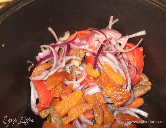 теперь в кастрюлю идут курага,лук и  помидор,соль,специи и тушится примерно минут 10