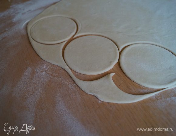 Отдохнувшее тесто делим на несколько частей и раскатываем в пласт и вырезаем кружочки, при помощи бокала или специального приспособления
