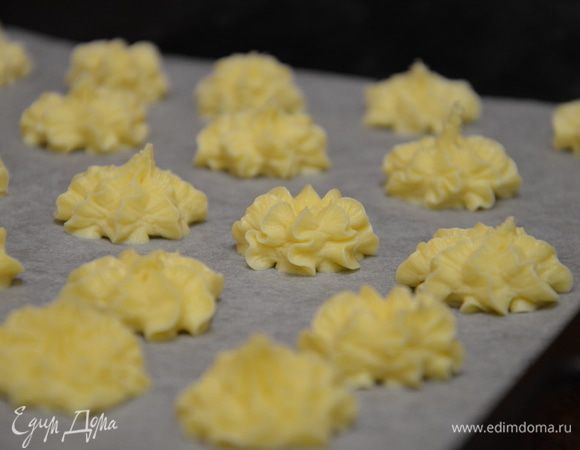 Противень застелить пергаментом, тестом наполнить кондитерский мешок, одеть насадку "звездочка" и отсадить тесто в виде звездочек, цветочков на пергамент.