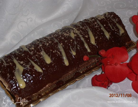 Сливки подогреть,добавить шоколад и масло дать раствориться.Oбмазать наш рулет и присыпать немного орехами.Поставить в холодильник на пару часиков пропитаться. Вот он готов и мы можем насладиться всем его вкусом. Приятного вам!!!!