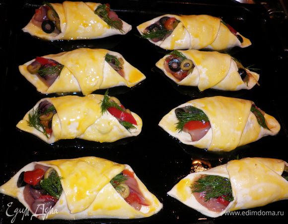 Соединить два противоположных края каждого квадрата. Получаются вот такие конвертики-башмачки. Тесто смазать взбитыми желтками. Уложить получившиеся башмачки на смазаный растительным маслом противень.
Выпекать в разогретой до 180 духовке 35-40 мин.