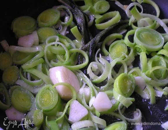 На смеси оливкового и сливочного масел обжарить лук-порей, чеснок (1 целиком раздавить, другой нарезать) и шалфей,