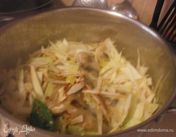 Займёмся капустой. Если есть возможность купить черную, тронутую первыми заморозками - хорошо. Если такой возможности нет, берём обычную капусту, нарезаем на крупные куски и под холодную воду, минут на 20. Как я и сделала. Даём стечь воде, обсушиваем бумажным полотенцем и нарезаем. Добавляем в кастрюлю с рёбрами. Туда же добавляем и ножки - ушки из другой кастрюли. Жидкость нам не нужна.