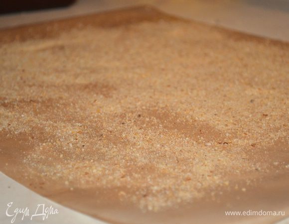 Теперь берем большой кусок пергамента, я взяла коврик для выпечки и мажем его растит маслом, затем присыпаем оставшимися сухарями. 