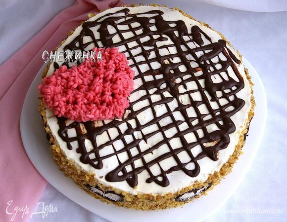 Перекладываем торт на блюдо, освободив от формы и бумаги. Для начала украсим сверху шоколадом. Берём оставшийся шоколад, растапливаем на водяной бане с молоком, хорошо размешиваем. С помощью пакетика с отрезанным кончиком рисуем волнообразные линии по верху торта.