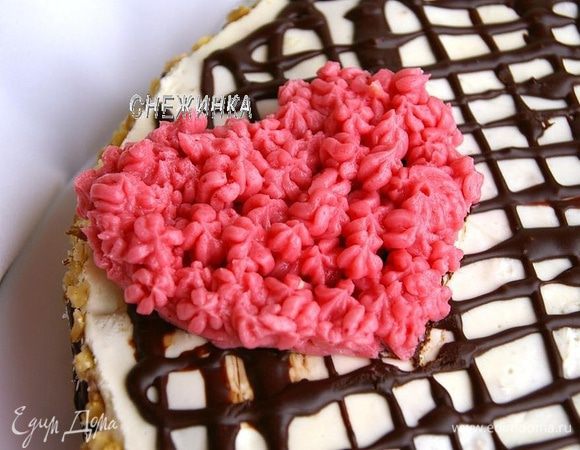 Для верхнего сердца наш розовый крем помещаем в кондитерский мешок. Вначале я на тортике пометила ножиком очертания сердца. Чтобы сердце выглядело объемным, сначала нанесла слой крема, просто очертив сердце и немного внутри него. А уже потом наносила небольшие цветочки по всему сердцу. 