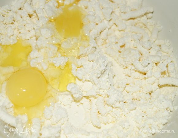 Творог смешайте с яйцами, сметаной и сахаром. Мешайте до растворения сахара.