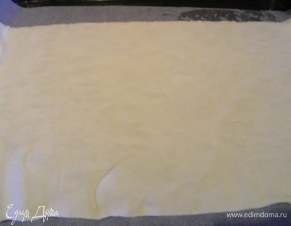 Слоеное тесто тонко раскатываем и выкладываем его на противень (лучше на бумагу для выпечки).
