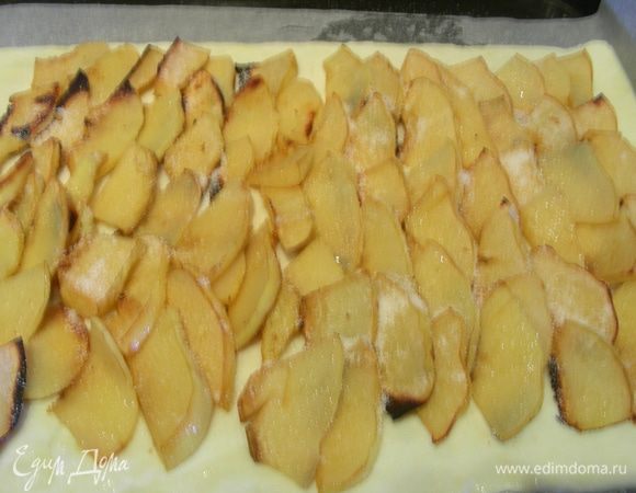 Выкладываен на него дольки айвы, немного отступая от краев. Сверху посыпаем сахаром. Края смазываем взбитым яйцом. Отправляем в духовку еще на 20 минут до золотистого цвета. Если у Вас очень мощная духовка, то температуру можно снизить до 180 гр. За 5 минут до готовности посыпаем пирог кедровыми орешками. 
