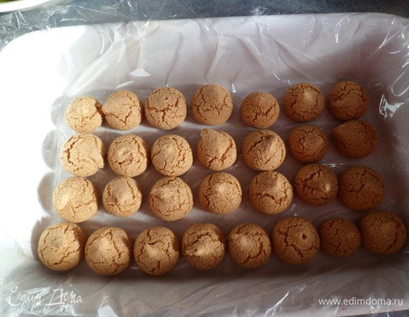 Берем форму, покрываем дно пищевой пленкой , укладываем миндальные печенюшки