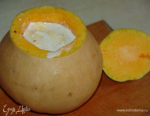 На дно тыквы положить небольшой кусочек сливочного масла и начинку. Оставляем немного места в тыкве на случай разбухания риса. Сверху кладем кусочек сливочного масла и заливаем сливками.