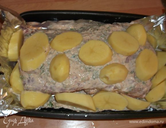 Обкладываем картошкой (по желанию, но уж больно хороша пропитанная мясным соусом), закрываем сверху фольгой, плотно запечатываем и ставим в разогретую до 220 гр духовку на час (каждый килограмм мяса берет час готовки, у меня 2 кг - значит 2 часа). Достаем готовое мясо, посыпаем оставшейся зеленью (аромат сногосшибательный), прикрываем фольгой и оставляем на 15 минут, нарезаем и подаем с гарниром.