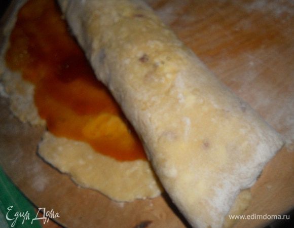 Достать тесто из холодильника, доску на которой будете раскатывать припылить мукой и раскатать прямоугольник, толщина пласта около 3 мм, смазать поверхность повидлом и свернуть рулетом очень осторожно, переложить на противень, застеленный бумагой для выпечки и выпекать при t 250 гр. до готовности (до золотистой корочки).