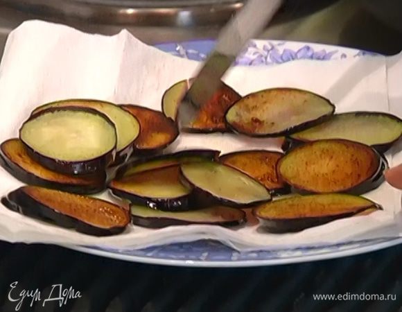 Разогреть в сковороде 2–3 ст. ложки оливкового масла и обжарить баклажаны с двух сторон, затем выложить на бумажное полотенце, чтобы убрать излишки жира.