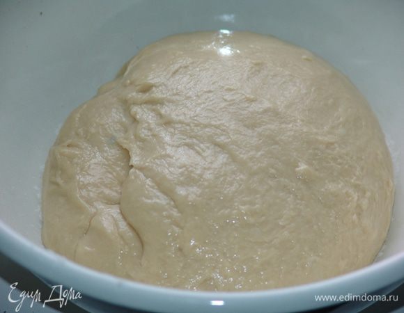 Половину муки постепенно добавляем в молочную смесь. Затем добавляем дрожжи поочередно с оставшейся мукой, перемешивая после каждой порции. Замешиваем тесто, накрываем полотенцем и даем постоять в тепле до увеличения объема в два раза. 