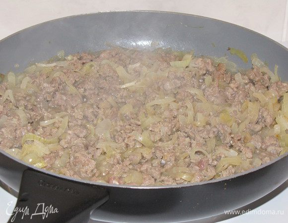 Рис промыть и оставить. Репчатый лук нарезать тонкими полукольцами и обжарить в разогретом масле, примерно 8 минут. Добавить фарш и готовить, разминая комки, пока мясо не поменяет цвет.
