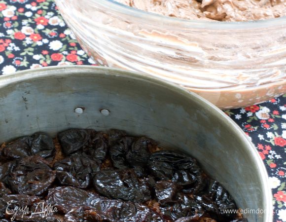 На остывший корж выложите чернослив, разрезанный на половинки