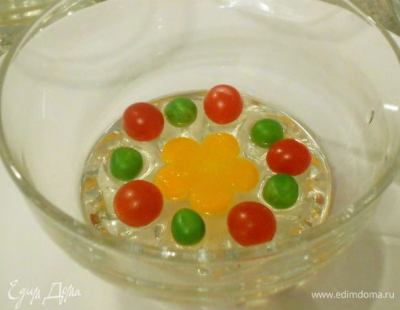 В подготовленные пластиковые, силиконовые или металлические формочки или мисочки налить по 3-4 ст.л. бульона и убрать в холодильник до застывания. В это время подготовить продукты для украшения: из моркови можно вырезать мелкие фигурки или просто ромбики, разобрать петрушку на листочки. Горошек лучше использовать замороженный-он более яркий. Залейте его на 10 мин кипятком и он готов. Для украшения можно использовать нарезанные оливки. Ваша фантазия ничем не ограничена!
На застывший слой желе выложить овощи, залить аккуратно бульоном и вновь дать застыть.