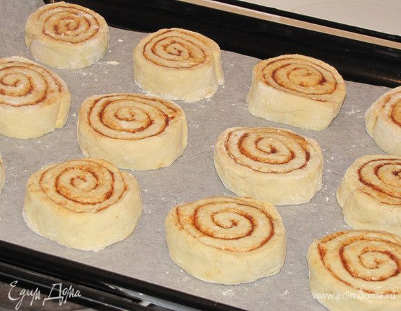 Разложить плюшки на застеленный бумагой для выпечки противень (или 2 противня) на расстоянии минимум 2 см. друг от друга. накрыть и дать подняться, 30 минут. Тем временем разогреть духовку до 225 град. 