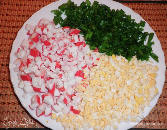Крабовые палочки нарезать кубиками. Яйца порубить. Лук вымыть, обсушить и нарезать колечками. 